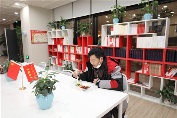 意外滯留在園區(qū)內(nèi)的快遞小哥收到了青年志愿者送來的一份熱騰騰晚餐，讓這個冬雪夜更暖心.jpg
